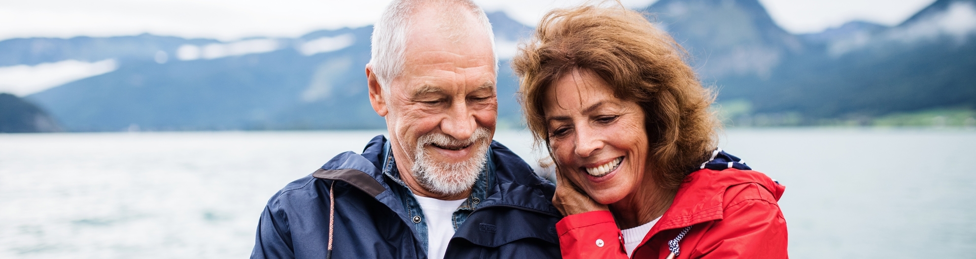 Mature couple looking at phone with mountains in the background